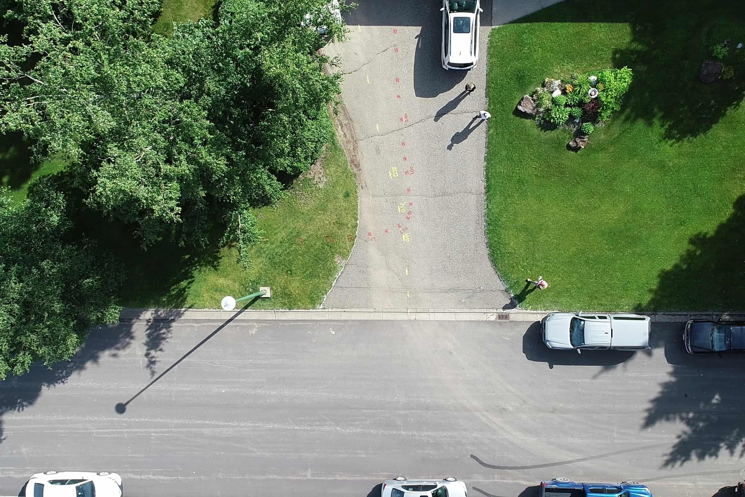 Top-down aerial view of a residential street during survey work