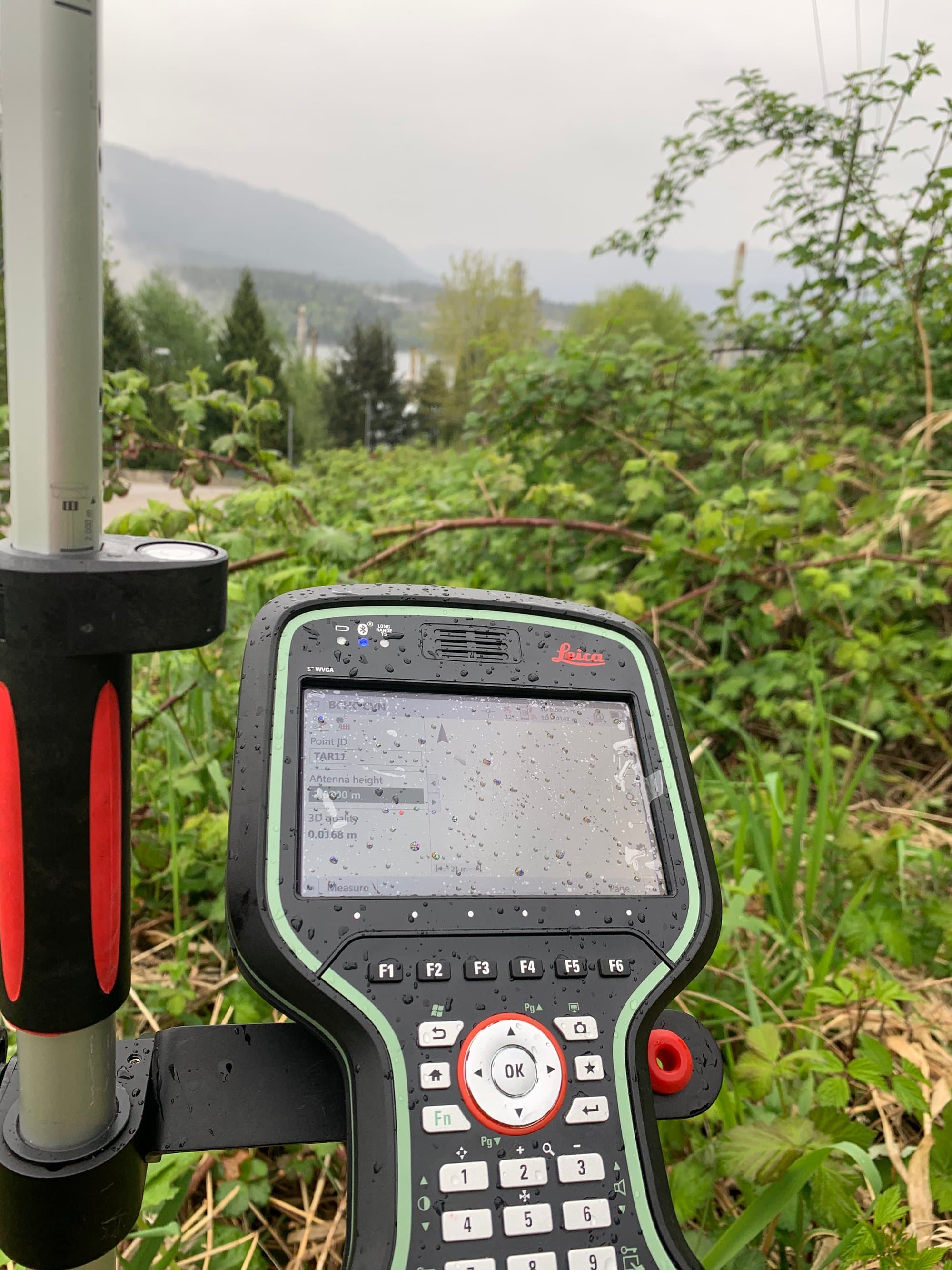 Field controller in the rain above a misty coastal inlet