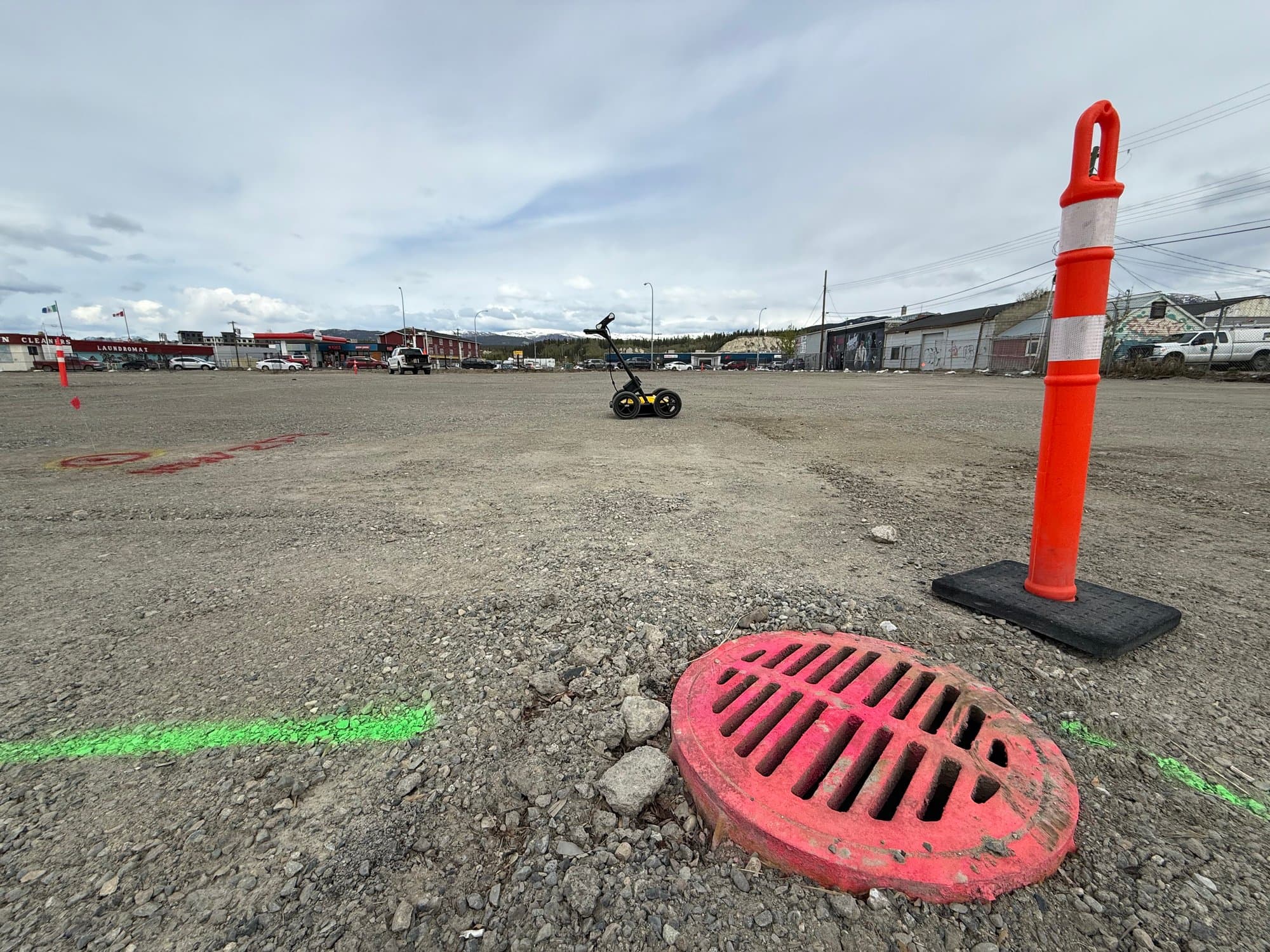 Ground-penetrating radar cart with locate markings on a gravel lot